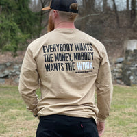 Man outdoors pictured from back wearing a WW sand colored long sleeve shirt. "EVERYBODY WANT$ THE MONEY, NOBODY WANTS THE WORK." screen printed on the back in black and white ink [WEWORKIN BRAND APPAREL printed small and lower right just below the word WORK.) Banded collar and cuffs. (Also wearing a WW Caramel/Black WW HUNT hat.)