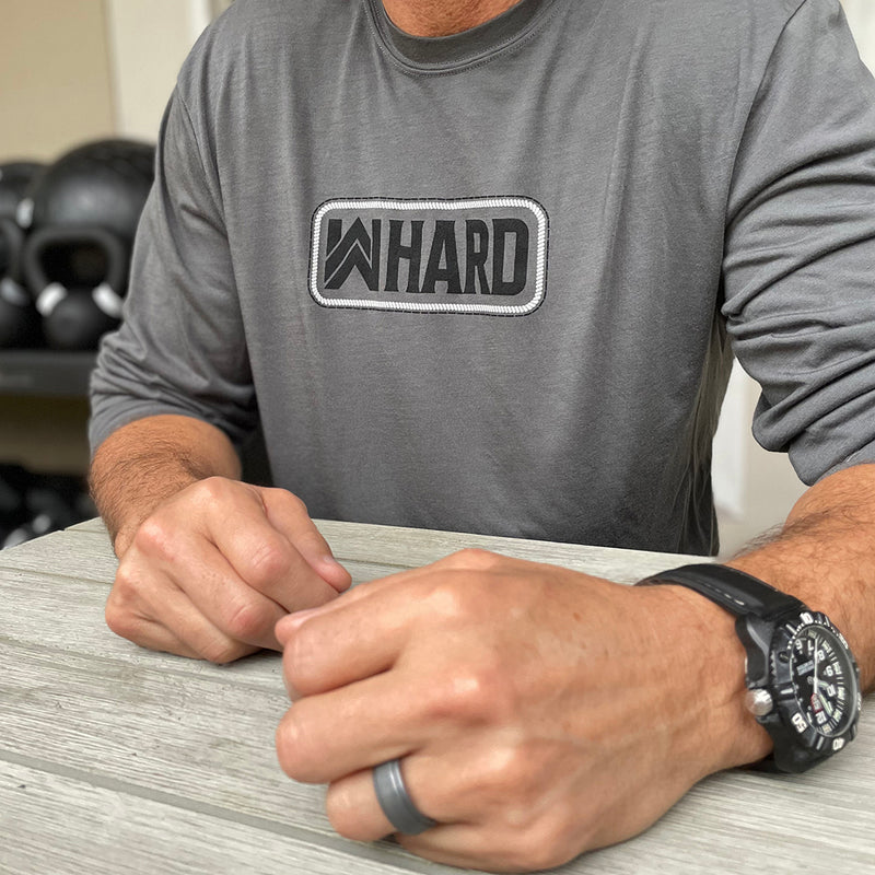 Man pictured from front wearing a WW long sleeve Smoke Grey color shirt. WW HARD "patch-style" graphic printed in black and white, on center chest.