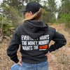 Woman pictured from back wearing a WW HARD Charcoal Grey Hoodie. "EVERYBODY WANT$ THE MONEY, NOBODY WANTS THE WORK" printed in bold on full back width in white ink, except the word WORK is printed in neon orange for emphasis. (WEWORKIN BRAND APPAREL printed small and lower right just below the full back imprint.) Banded cuffs and waist. Hood down on back.