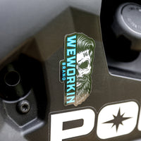 WeWorkin Brand sticker on a utility vehicle This WEWORKIN Brand Bearded Skull sticker is die-cut and printed in Teal blue and white on a black background. Top quality vinyl sticker—outdoor weather resistant, scratch/sun-proof (UV Laminated White Polypropylene). Sticker measures approx 1.75"W x 3.5"H