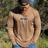 Man pictured outdoors, from the front, in a WE WORKIN ultralight weight, woodland brown long-sleeved tee—center chest screenprinted with the WW HUNT and ELK image in our signature "patch" style (WW icon/text/elk graphic in black ink, outer outline in black ink, inner "rope" in white ink).